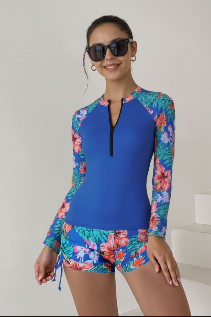 Sporty women's rashguard two-piece swimsuit with tropical print, offering sun protection for active swim.