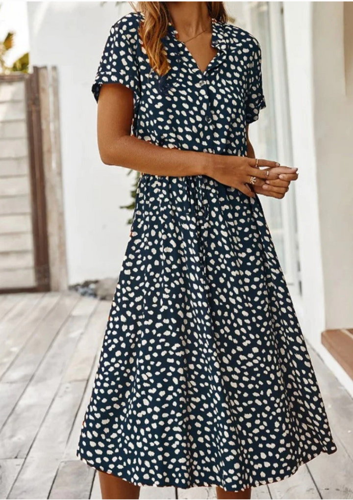 Versatile spring/summer spotted midi dress for women, complete with a button-down design and flutter sleeves.