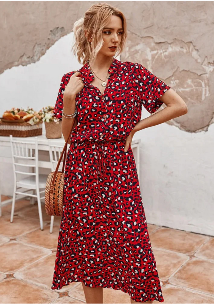 Elegant women's spotted midi dress, button-down style, with flowy flutter sleeves for a feminine touch.