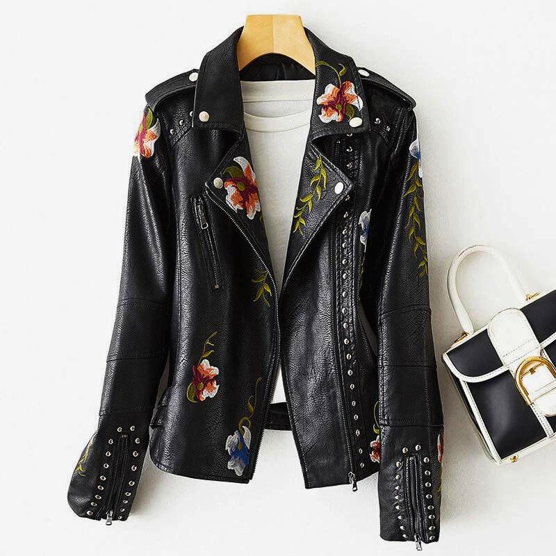 Beige women's statement jacket featuring intricate floral embroidery and stylish metal studs. Edgy fashion outerwear.