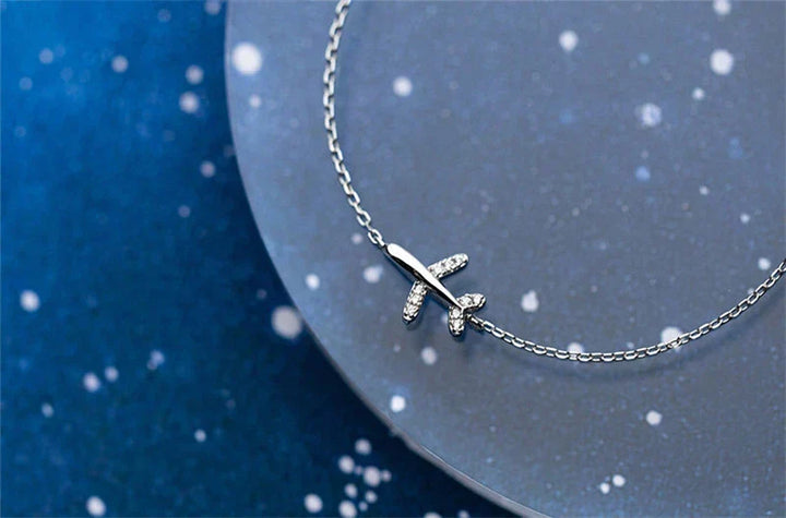 Elegant women's sterling silver bracelet featuring a polished plane charm, symbolizing wanderlust and adventure.