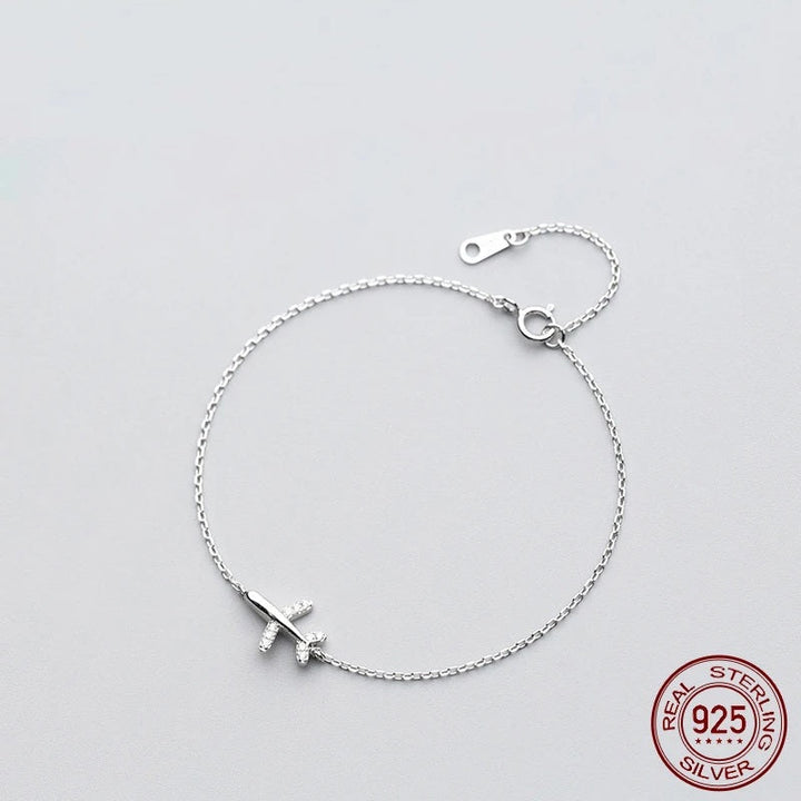Women's silver plane charm bracelet, sterling silver, travel jewelry, wanderlust fashion accessory for adventure.