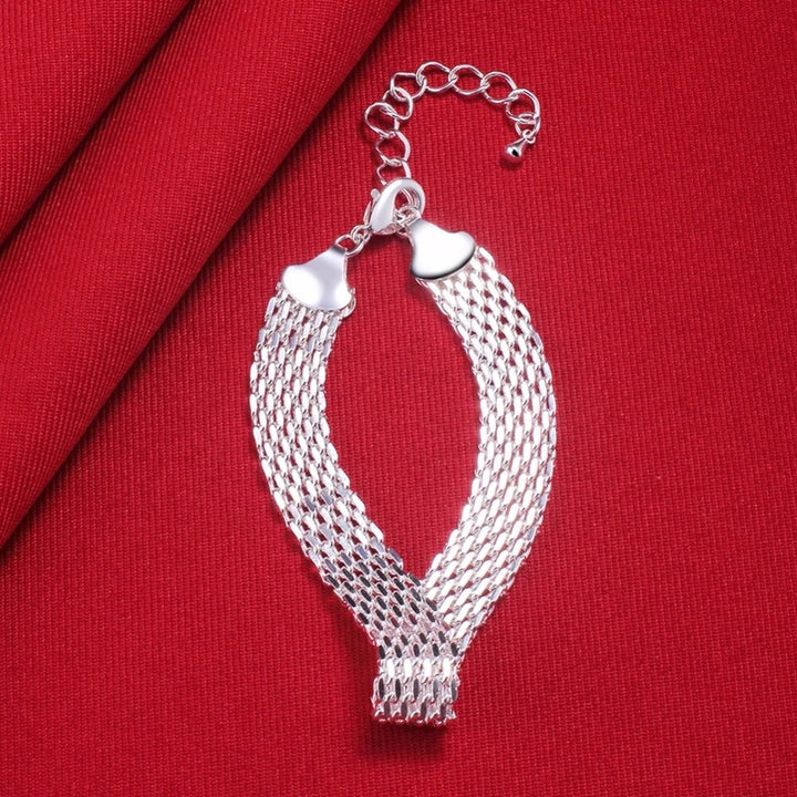 Handcrafted sterling silver braided lucky charm bracelet for women. Adjustable wrist accessory.