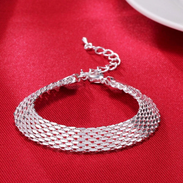 Close-up of a delicate women's silver braided bracelet featuring a unique lucky charm.