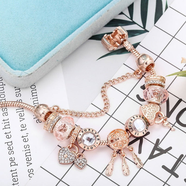 Stylish women's sterling silver dreamcatcher charm bracelet, featuring delicate pink accents, ideal fashion jewelry.