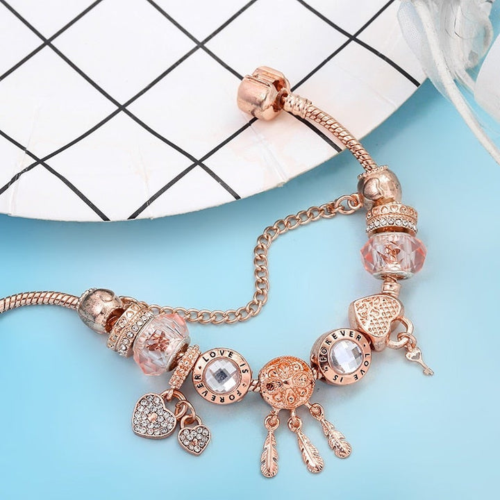 Close-up of a women's sterling silver dreamcatcher charm bracelet with a pink stone, a beautiful symbolic gift.