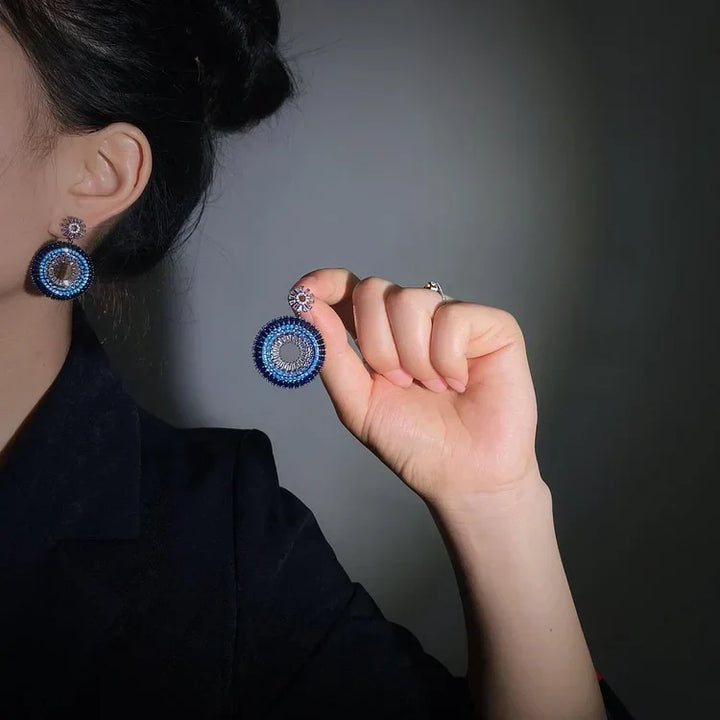 Dainty sterling silver evil eye stud earrings for women, featuring a sapphire blue center & clear zirconia