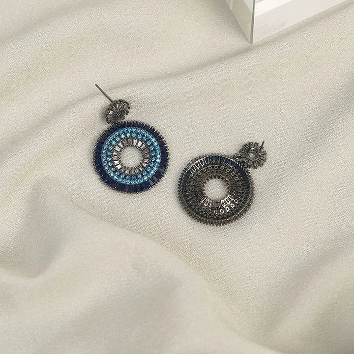 Close-up of women's sterling silver evil eye stud earrings, with vibrant blue and white enamel detailing