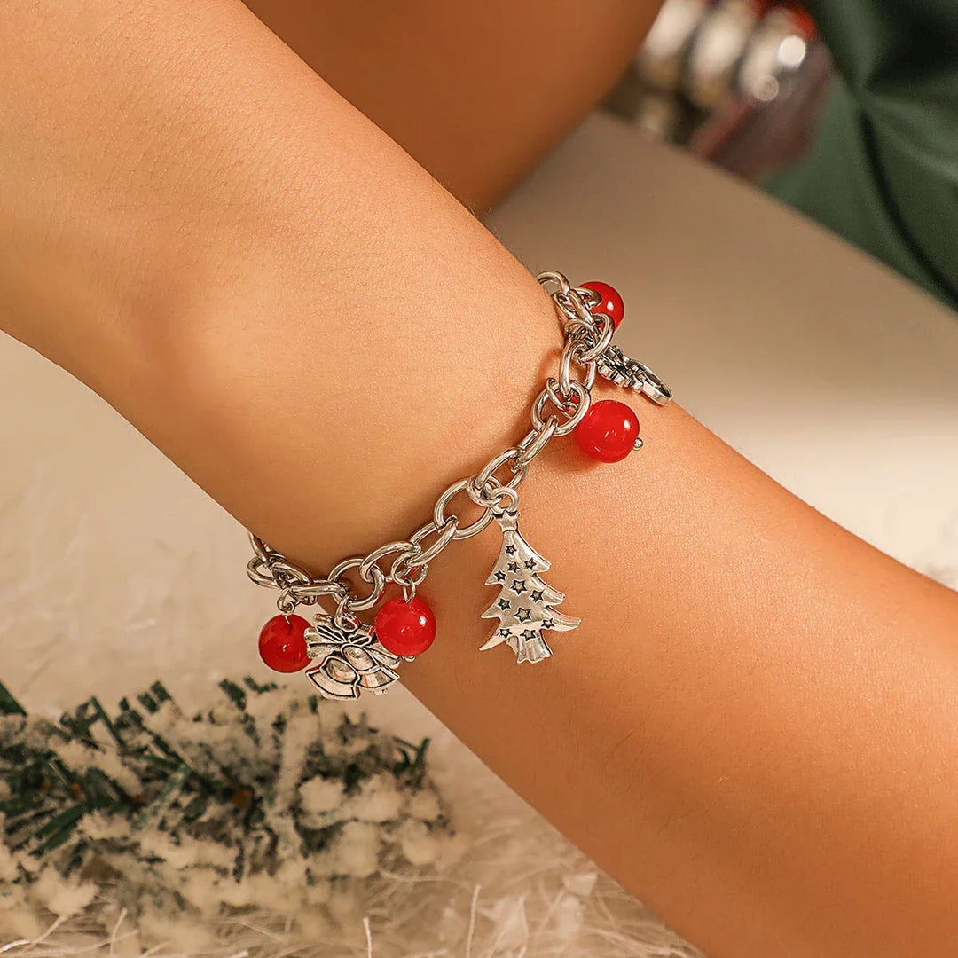 Close-up of a women's festive sterling silver charm bracelet, showcasing intricate holiday charms.