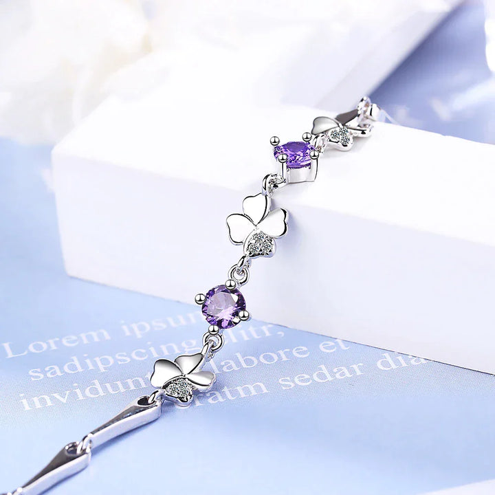 Close-up of an elegant sterling silver four-leaf clover charm bracelet, a lucky women's jewelry accessory.