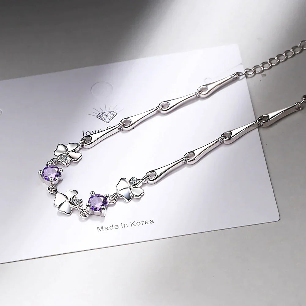 Dainty women's four-leaf clover charm bracelet in sterling silver, bringing luck and elegance to any outfit.