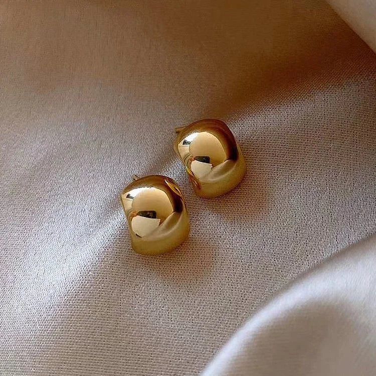 Elegant women's sterling silver hoop earrings with gold finish, perfect for subtle or bold fashion statements.
