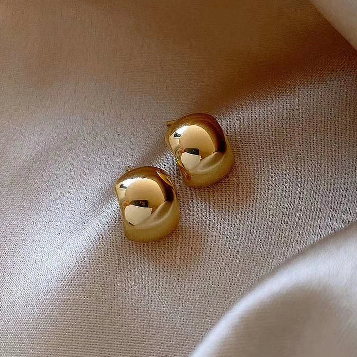 Elegant women's sterling silver hoop earrings with gold finish, perfect for subtle or bold fashion statements.