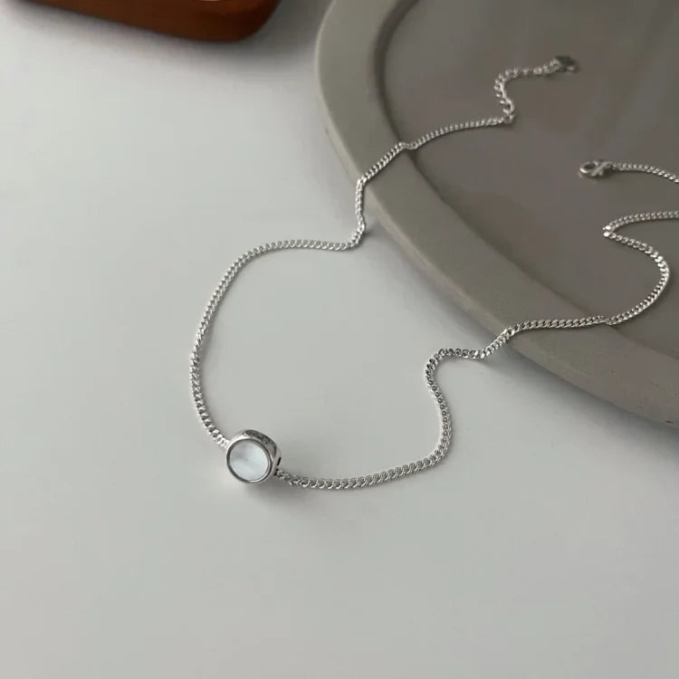 Playful sterling silver necklace for women, featuring a double-sided smiley charm. Trendy jewelry gift idea.