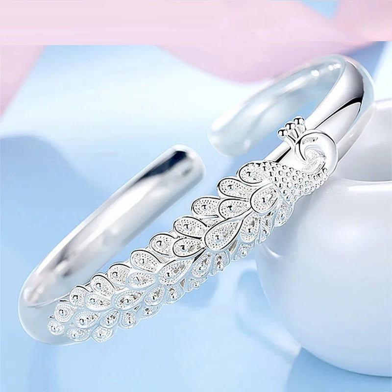 Elegant women's sterling silver bracelet featuring a beautiful peacock charm. A lovely gift for her.