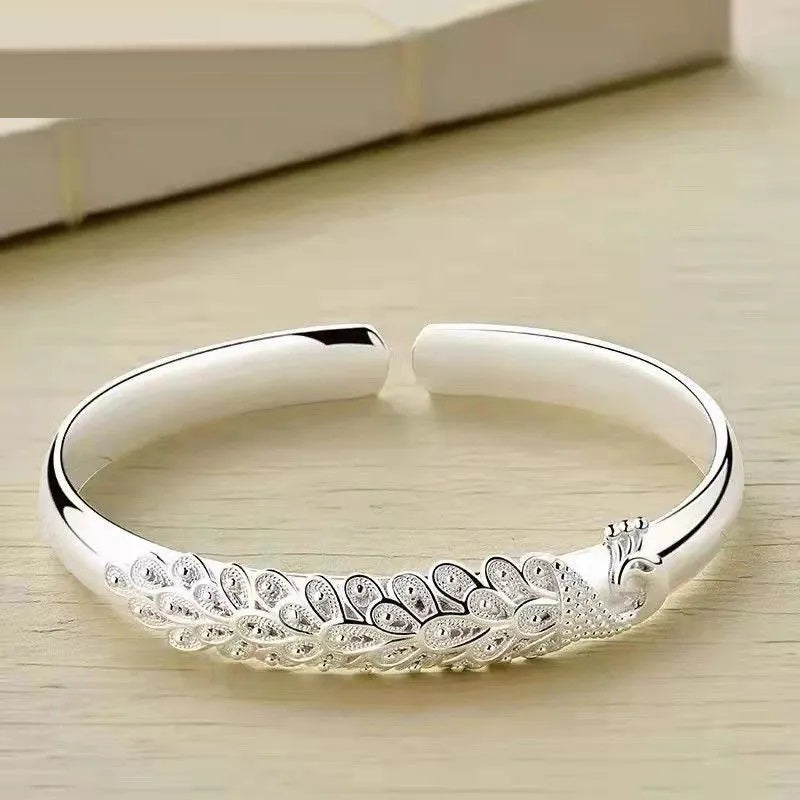 Delicate sterling silver peacock charm bracelet for women, an elegant silver bracelet for any occasion.