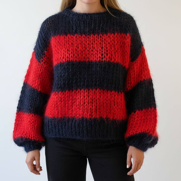 Knitted women's oversized sweater with a vibrant multi-color stripe pattern, making a bold fashion statement.