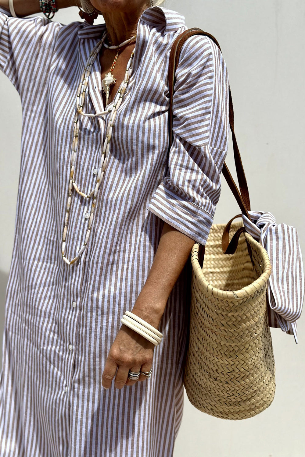 Chic striped midi dress for women with a button-down closure and collar, offering a relaxed and stylish silhouette.