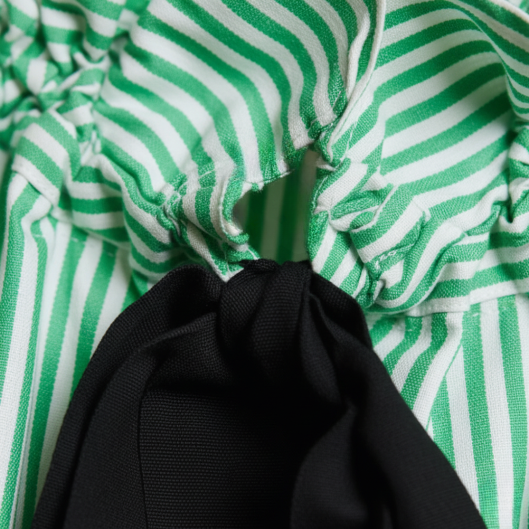 Professional women's striped blouse with relaxed fit, balloon sleeves, and a sophisticated bow tie.