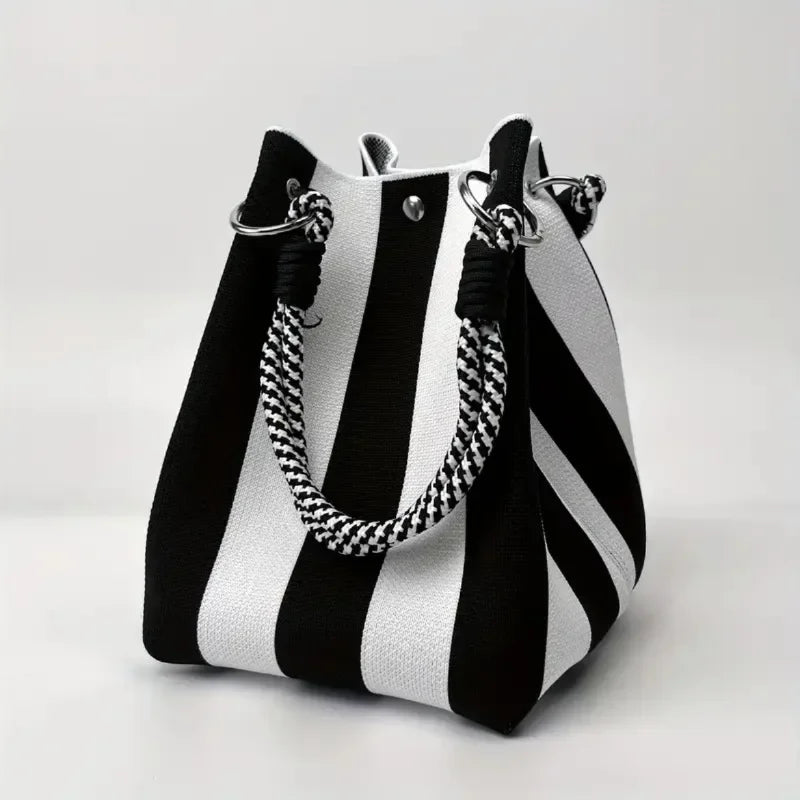 Close-up of unique design details on a women's canvas mini bucket bag. Stylish, compact shoulder/crossbody fashion accessory.