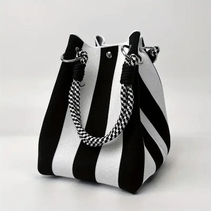 Close-up of unique design details on a women's canvas mini bucket bag. Stylish, compact shoulder/crossbody fashion accessory.