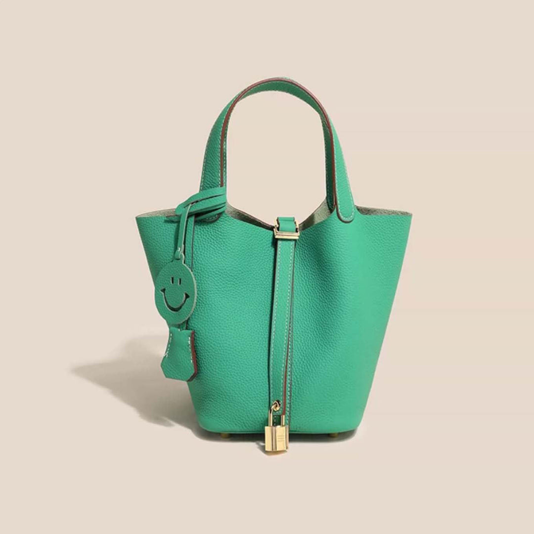 Side profile of a women's fashionable leather bucket bag, showcasing its elegant silhouette and strap.