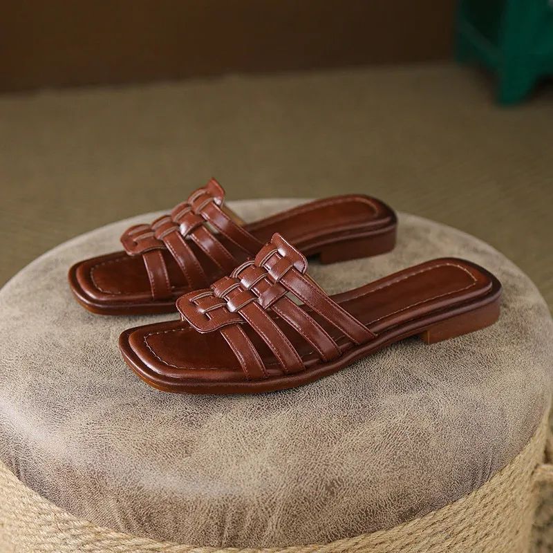 Comfortable women's brown flat slide sandals with unique geo cutout design.