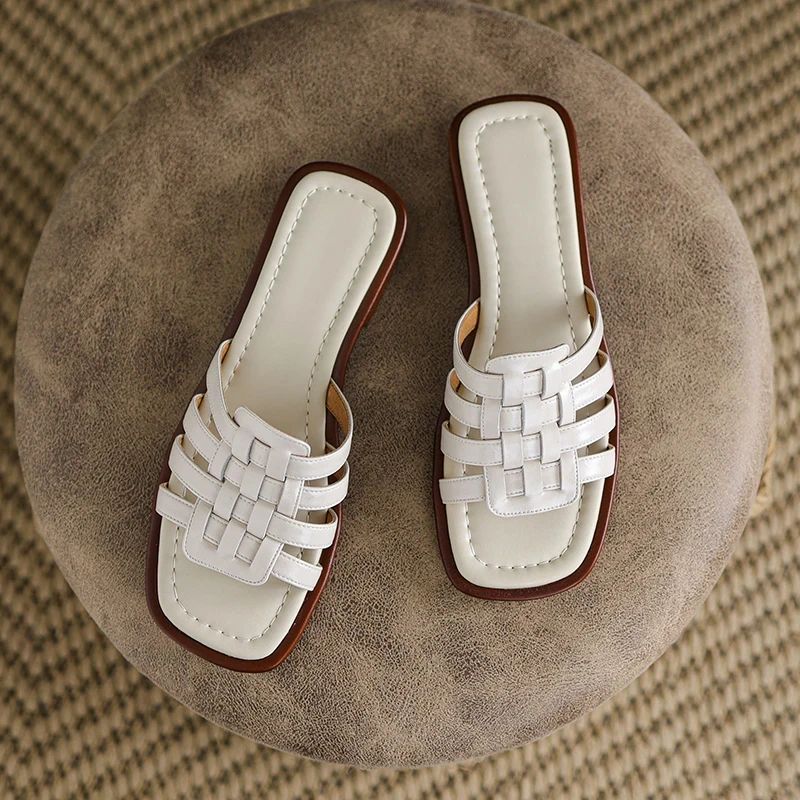 Close-up of the stylish geo cutout detail on women's white slip-on slide sandals.