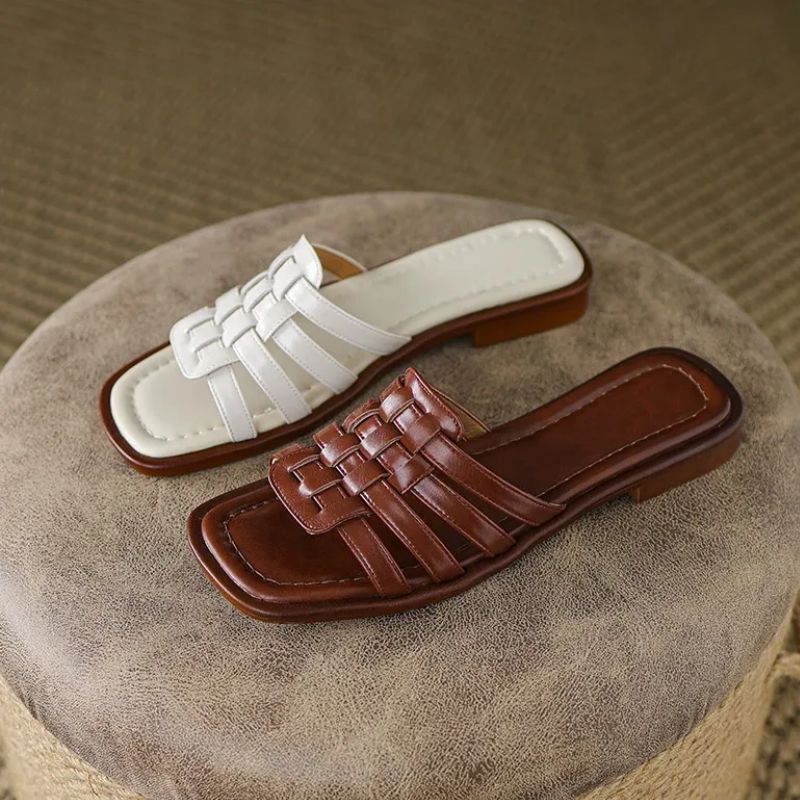 Stylish women's white & brown flat slide sandals, featuring geo cutouts & cushioned comfort.