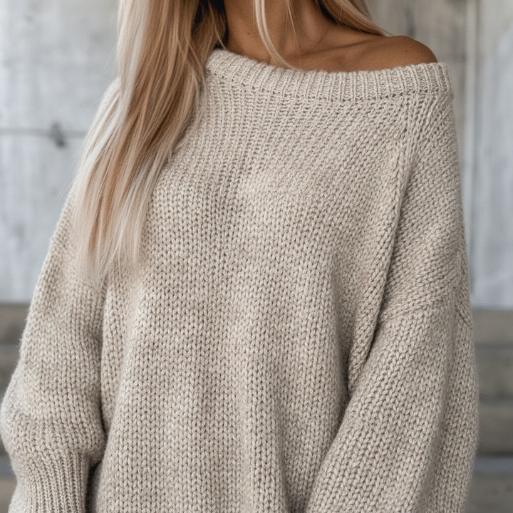 Close-up of women's off-shoulder knitted jumper, showcasing the stylish knitwear texture