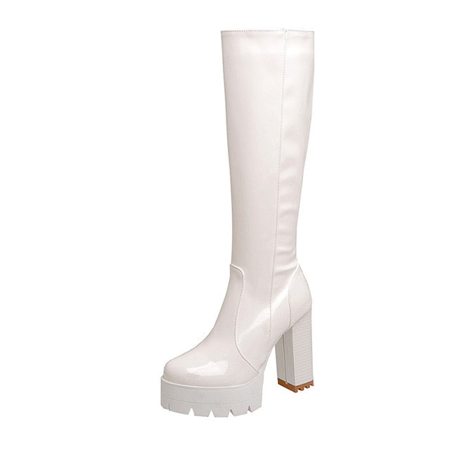 Close-up of women's long studded boots featuring stylish design, chunky platform heel. Perfect party & winter boots.