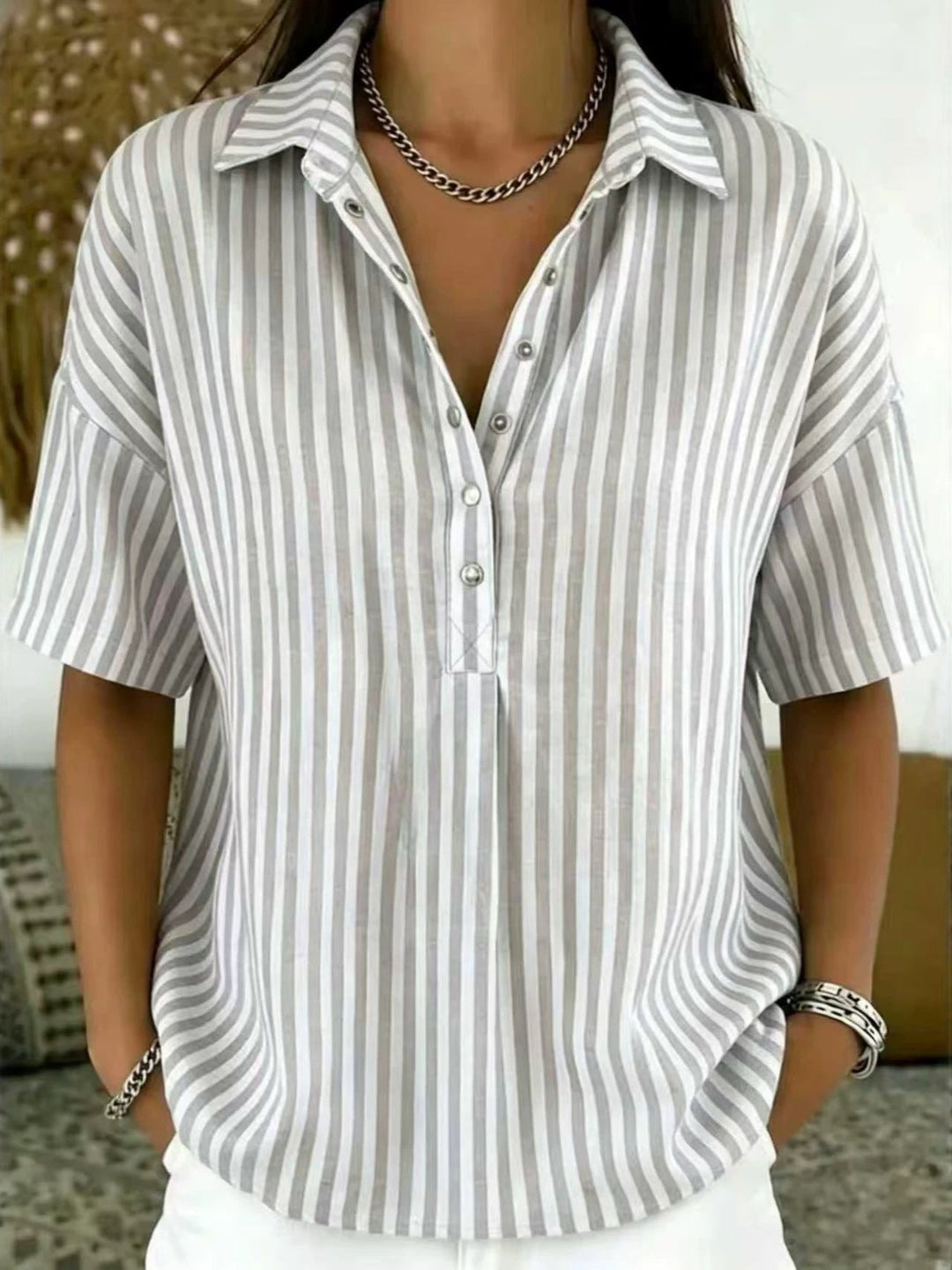 Stylish women's casual top featuring vertical stripes and a practical half-button front.