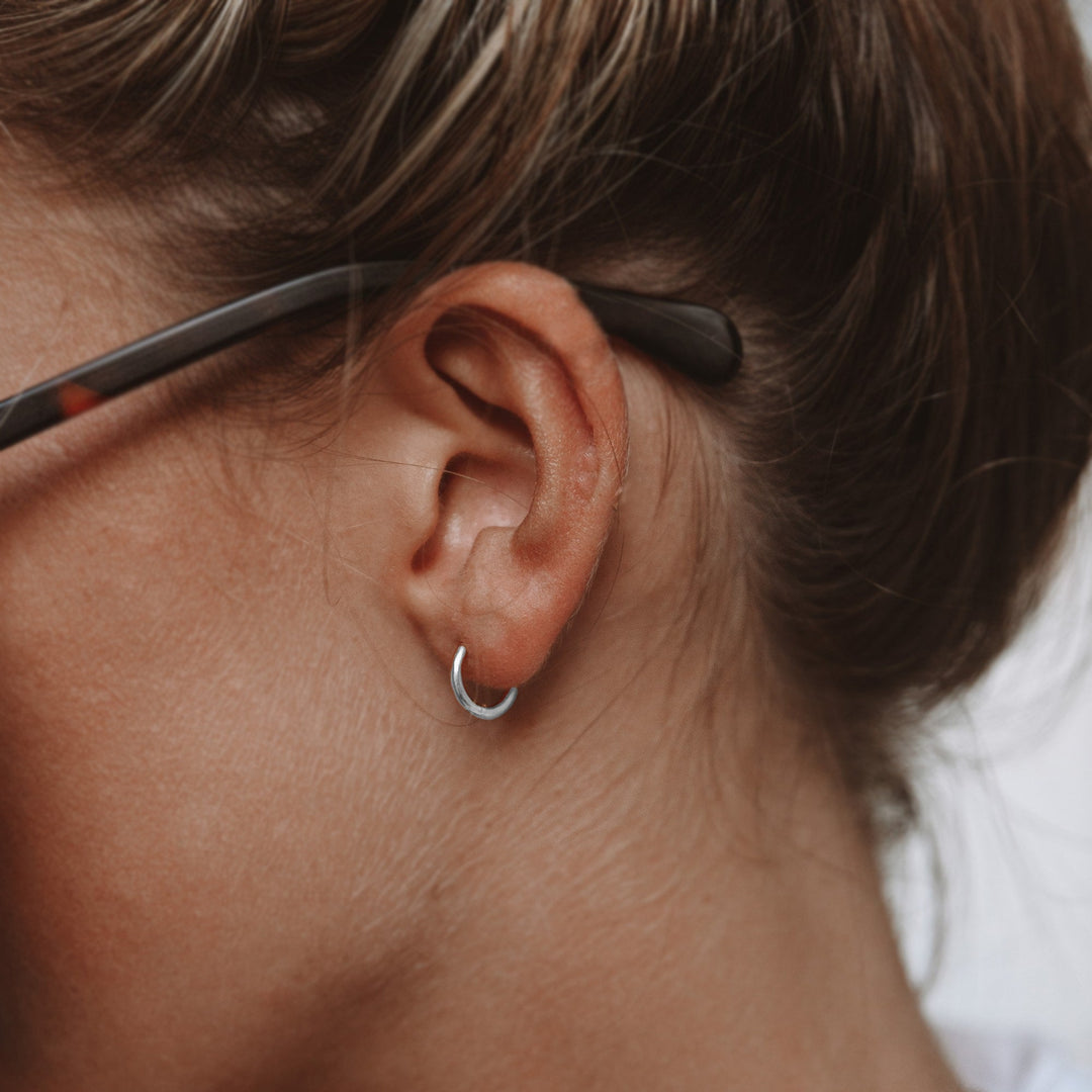 Waterproof silver small hoop earrings, subtle and durable for active women.