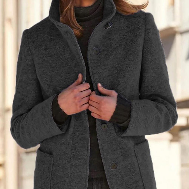Polished women's mid-length tailored coat with front button detail. Versatile work or smart casual fall/winter outerwear.