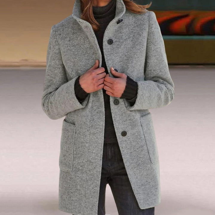 Chic women's tailored mid-length coat, buttoned. Essential fall/winter outerwear for a sophisticated ladies' fashion statement.