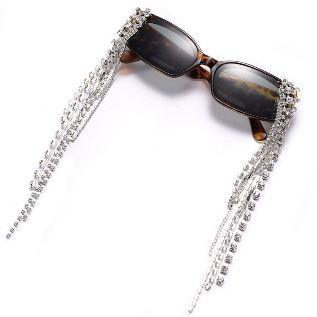 Fashionable women's plastic frame sunglasses with tassels, rhinestones, and UV400 polycarbonate lenses.