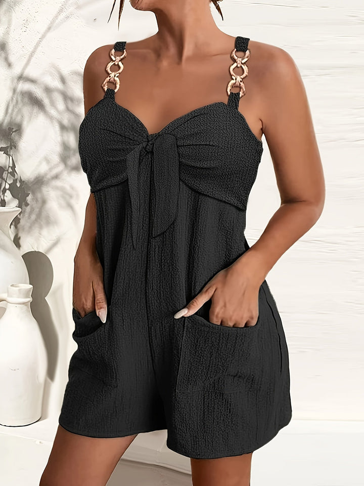 Women's textured bow front romper with elegant chain straps for summer parties.