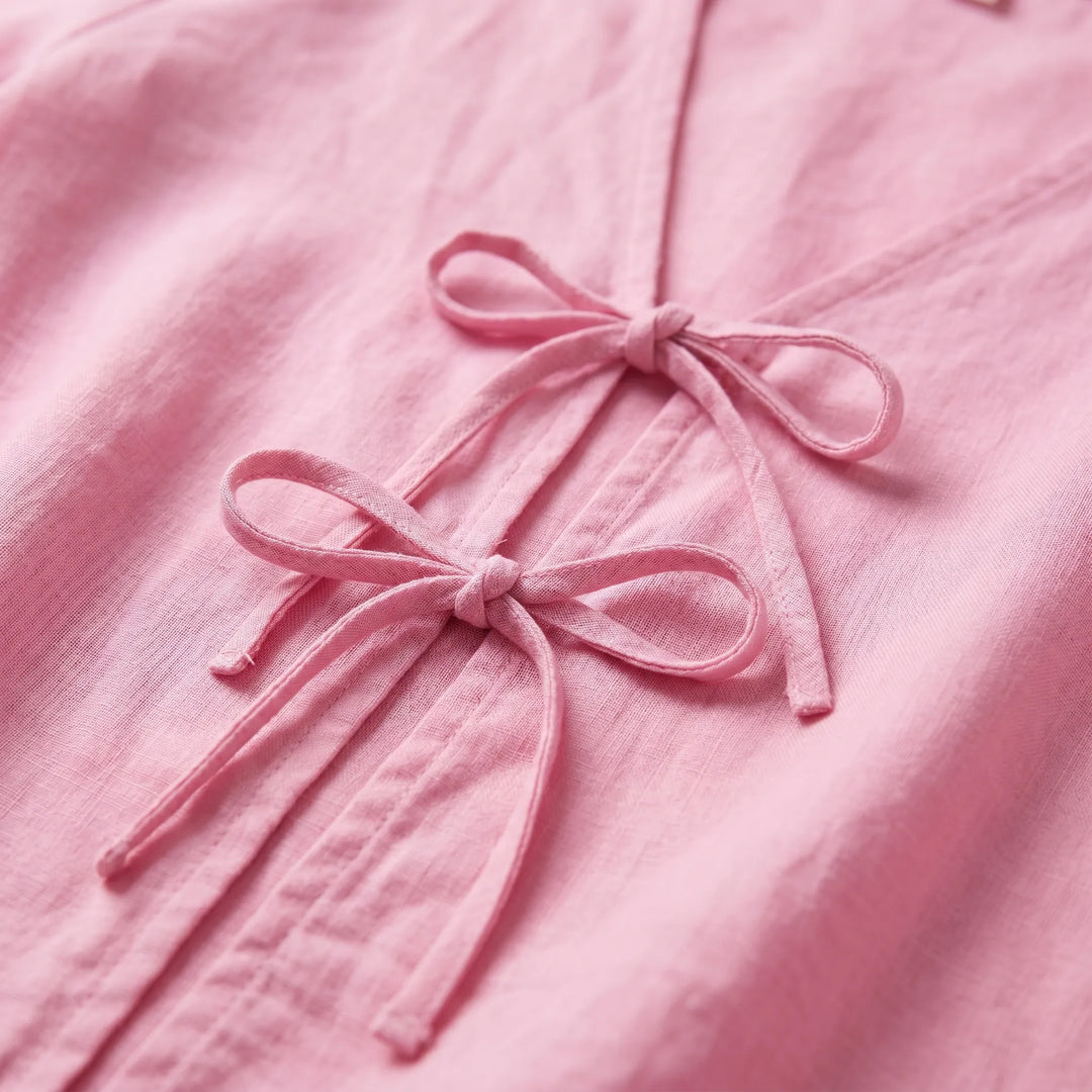Woman models a stylish, lightweight tie-front blouse for summer. Relaxed fit long-sleeve top for casual fashion.