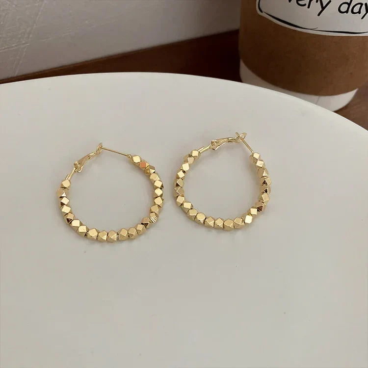 Silver faceted hoop earrings, a classic and versatile addition to womens jewelry.