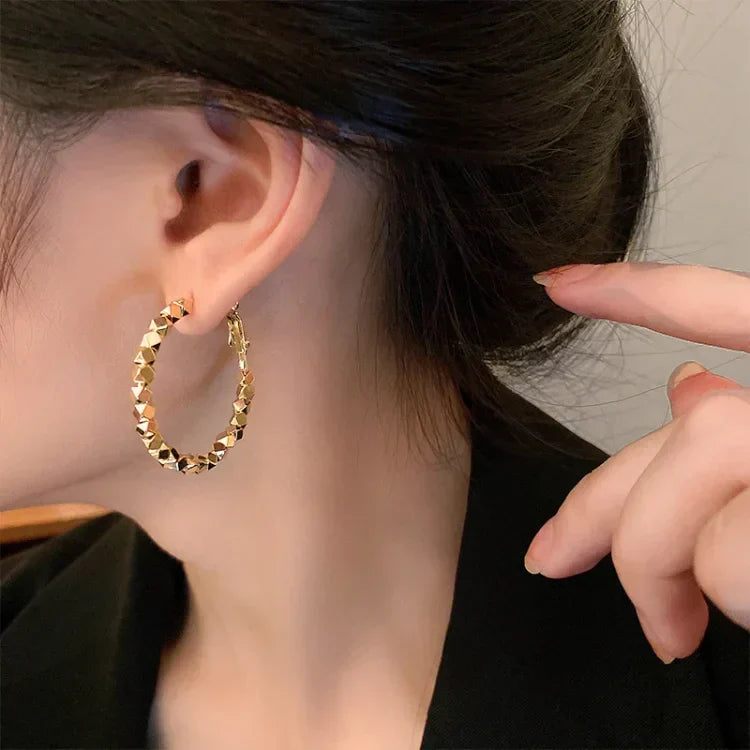 Timeless gold hoop earrings with delicate facets, ideal for elegant women's style.