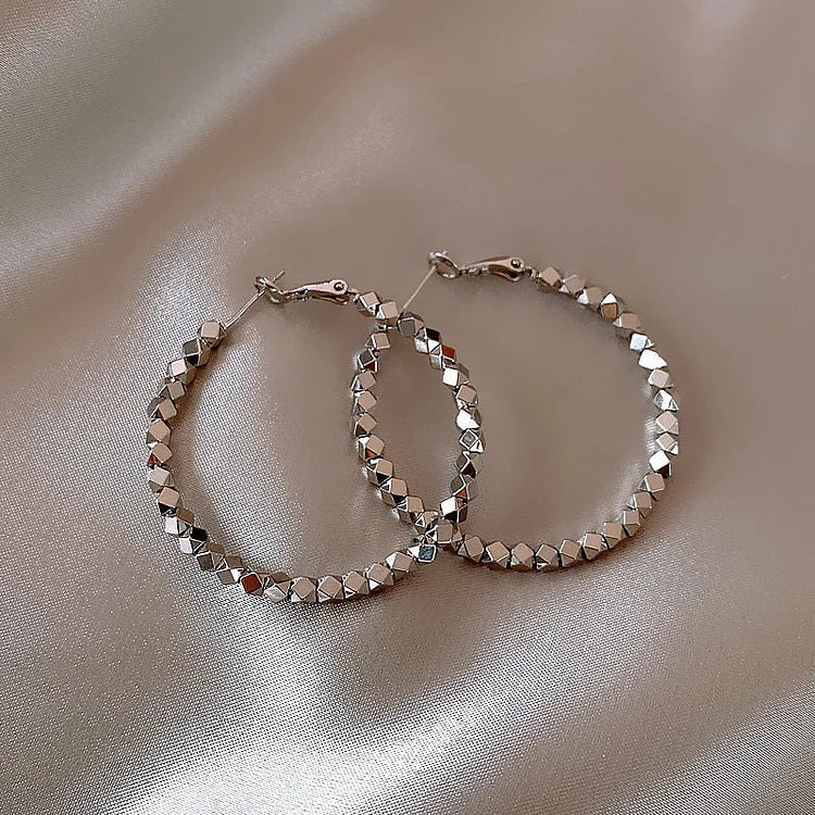 Minimalist women's faceted hoop earrings in silver, perfect for everyday elegance.