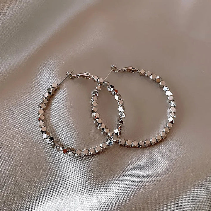 Minimalist women's faceted hoop earrings in silver, perfect for everyday elegance.