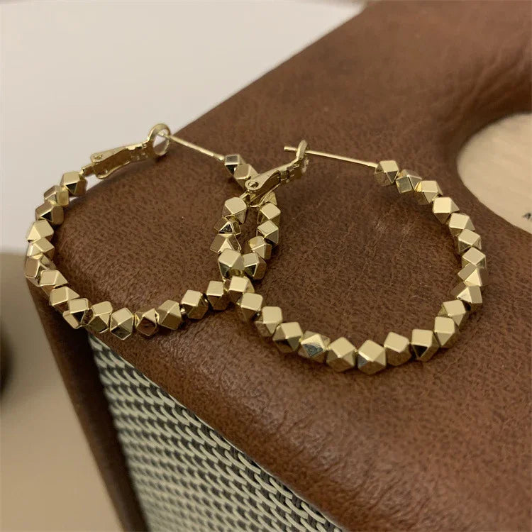 Versatile faceted gold hoop earrings, a must-have for any women's jewelry collection.