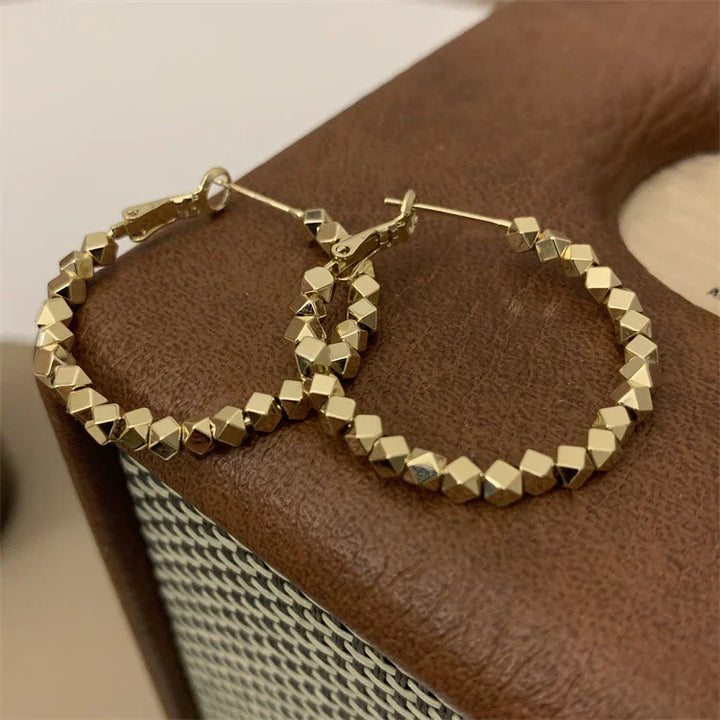 Versatile faceted gold hoop earrings, a must-have for any women's jewelry collection.