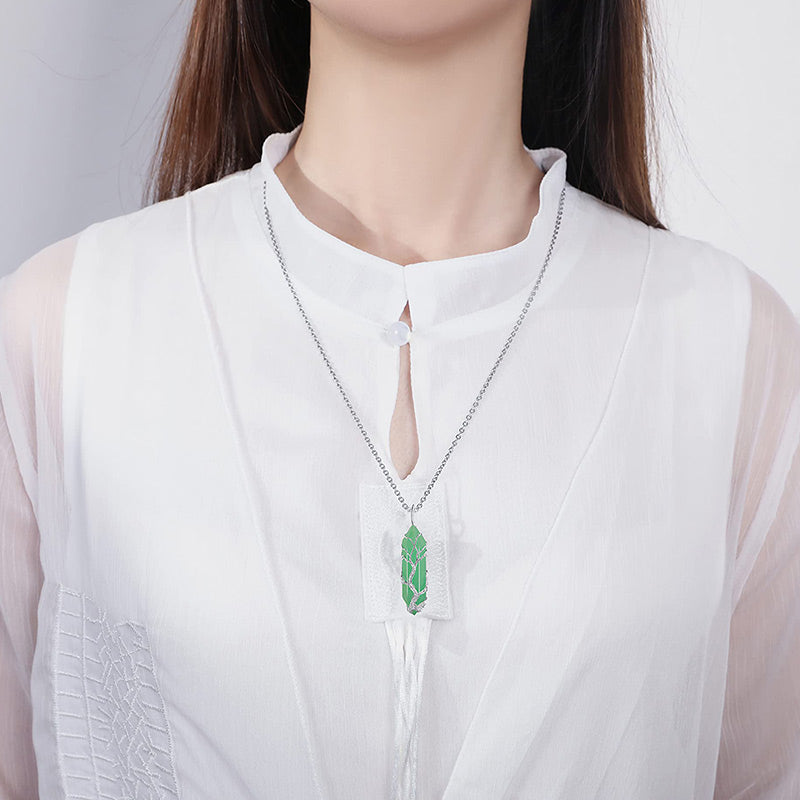 Adjustable Tree of Life necklace with a shimmering crystal and polished gemstone.