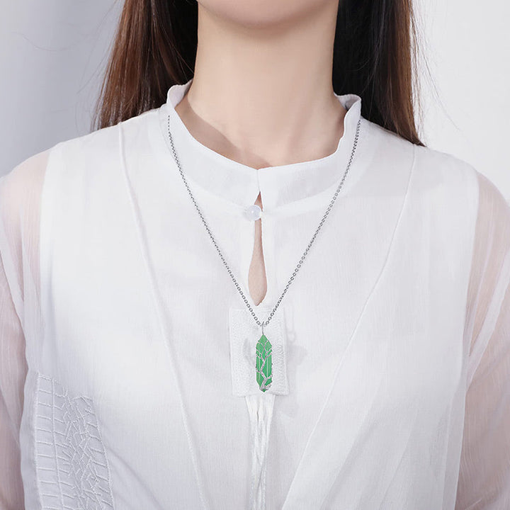 Adjustable Tree of Life necklace with a shimmering crystal and polished gemstone.