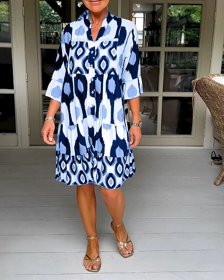 Casual women's tiered dress with an abstract print, 3/4 sleeves, and button placket for everyday wear.