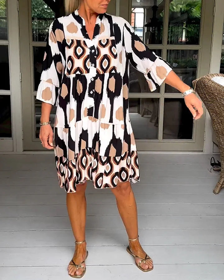 Trendy tiered women's dress with a striking abstract print and 3/4 sleeves, suitable for everyday wear.
