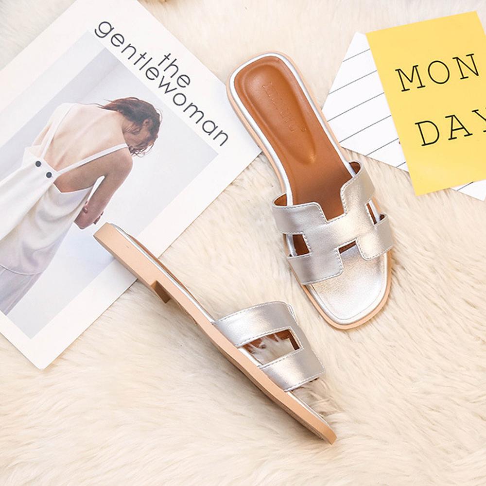 Chic women's H-profile slide sandals, elegant flat footwear for trendy summer fashion.