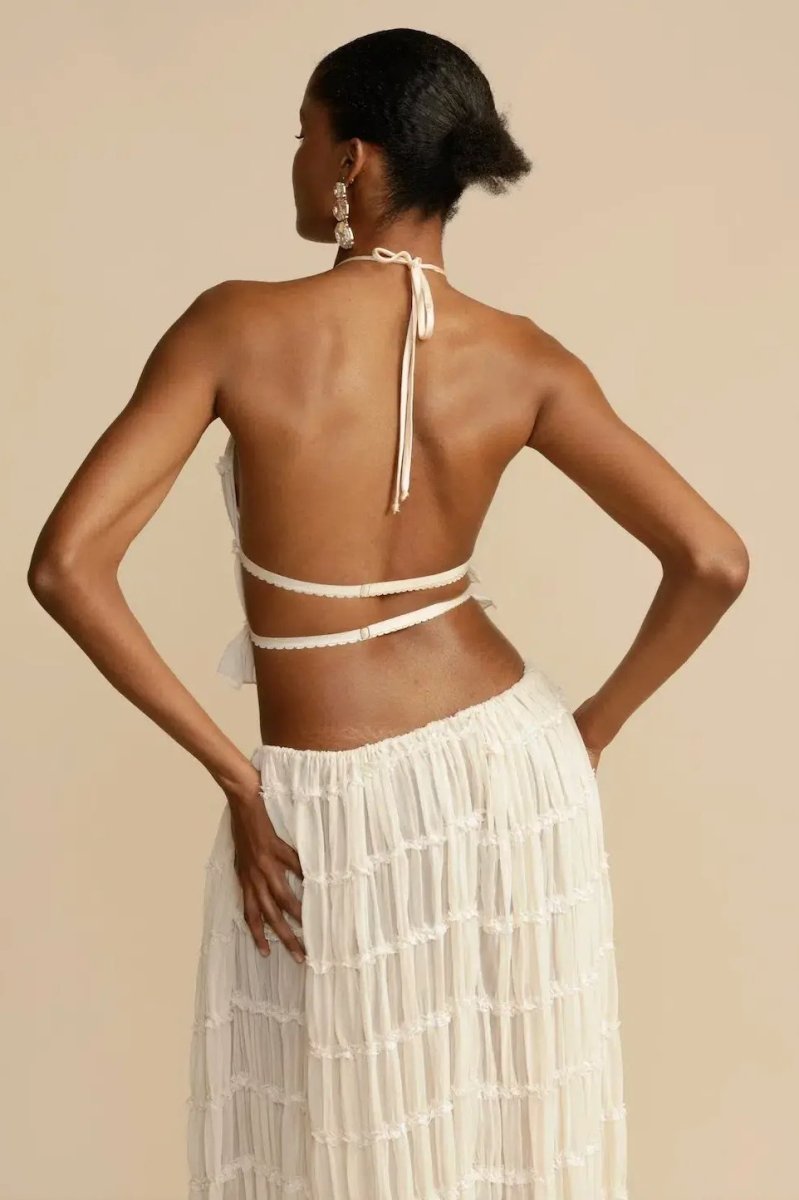Trendy women's summer outfit: a sleeveless halter top and a full, flowy maxi skirt two-piece set for vacations.